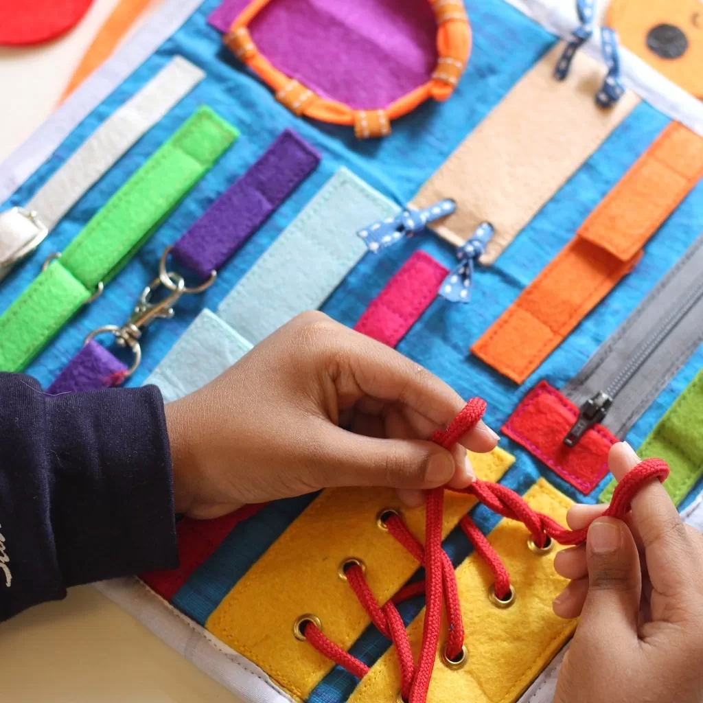 groiwng-hands-trying-to-knot-min Felt Busy Board with 16 life skills - Image 1